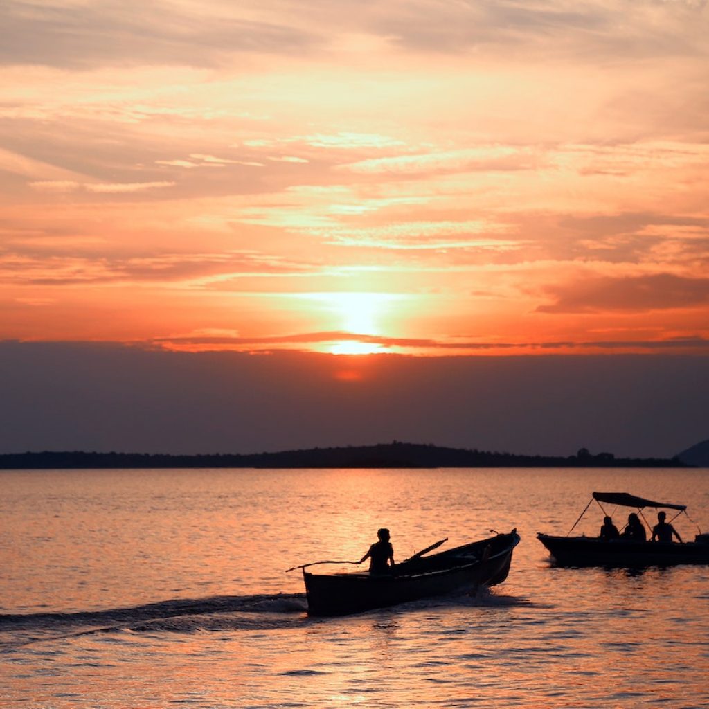 Sunset reflecting on Lake Kivu with local fishermen nearby